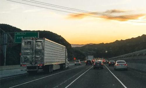 Heavy duty trucks and smaller cars stuck in traffic.